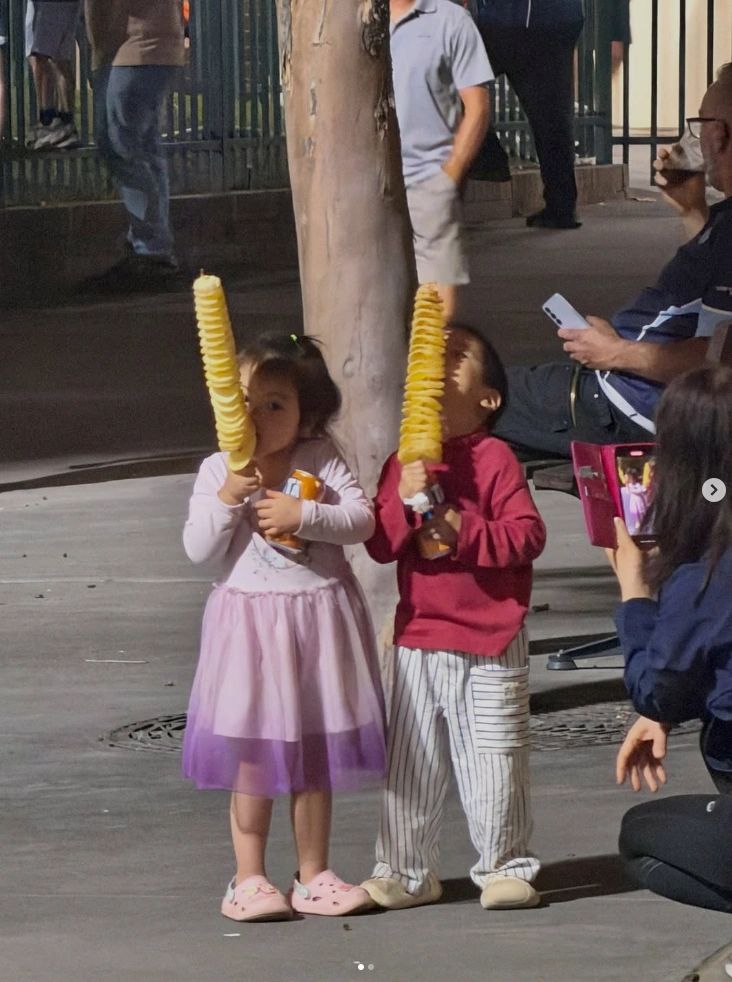 Children holding spiral chip treats at an outdoor event